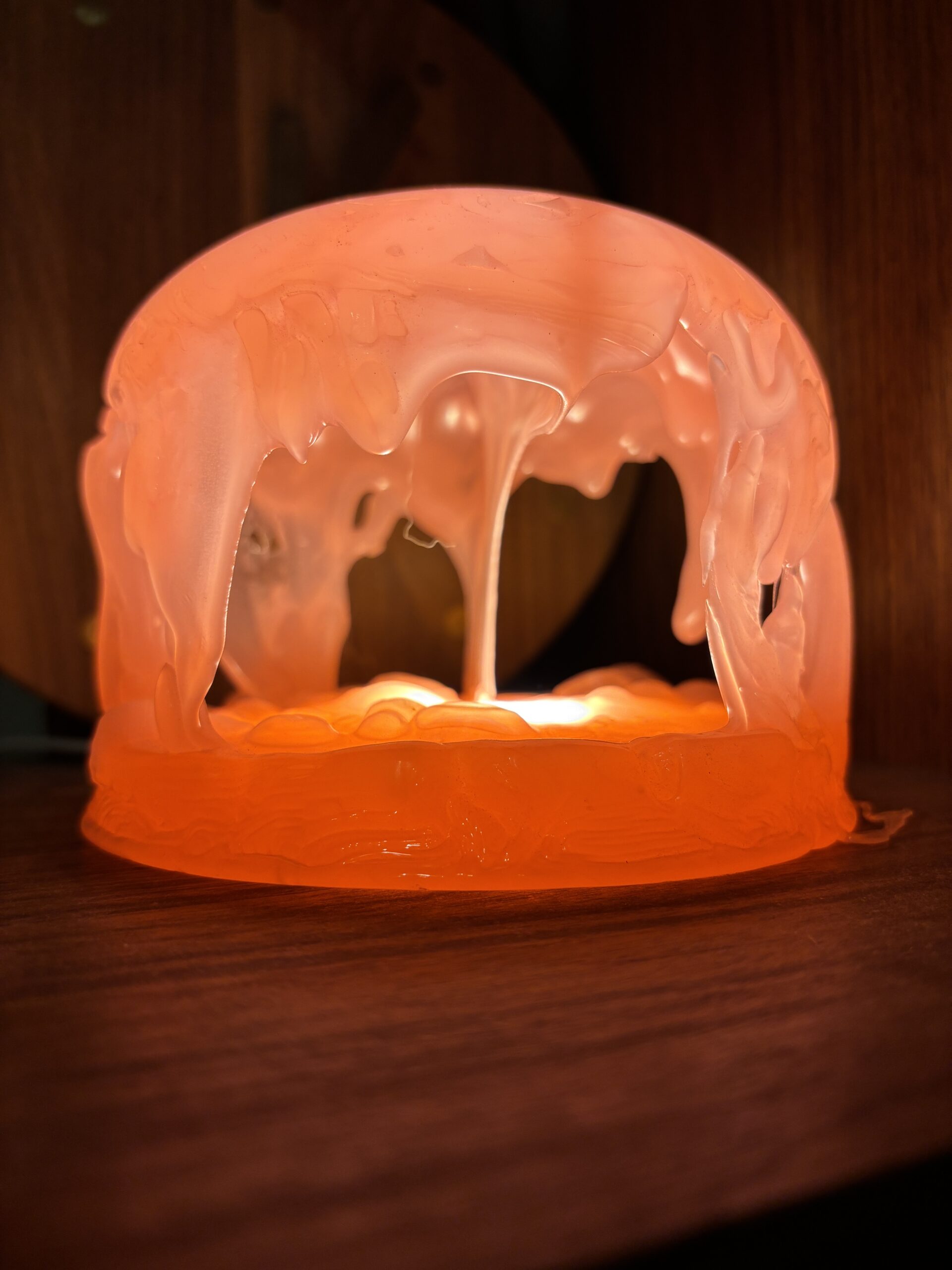Close-up of an orange jellyfish dome lamp's glowing cave-like underside